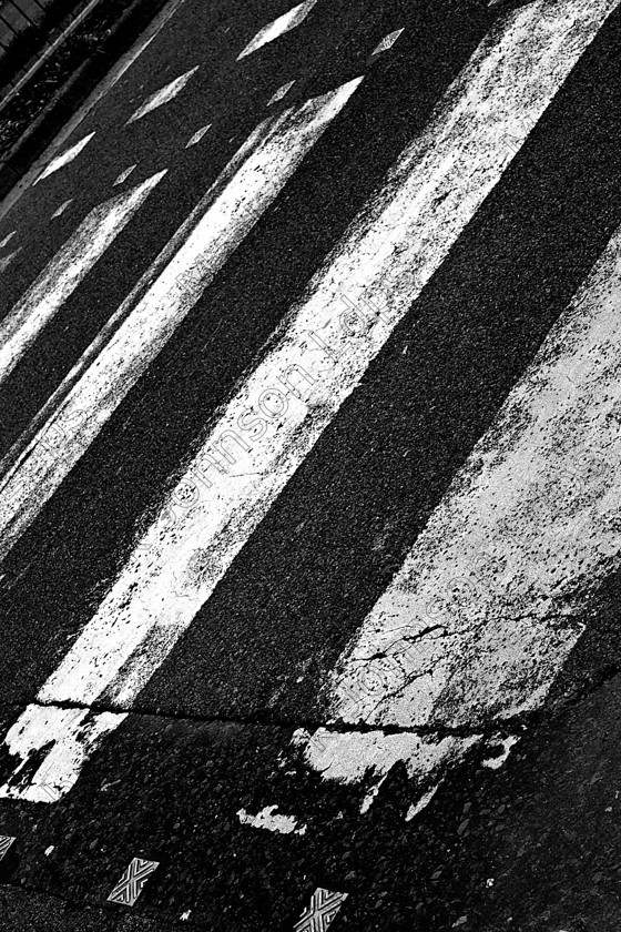 MG 01542009 
 A zebra crossing taken on an angle. 
 Keywords: zebra, crossing, road safety, tarmac, cracked surface, mono, black, and, white, stripes, angled, white stripes, school