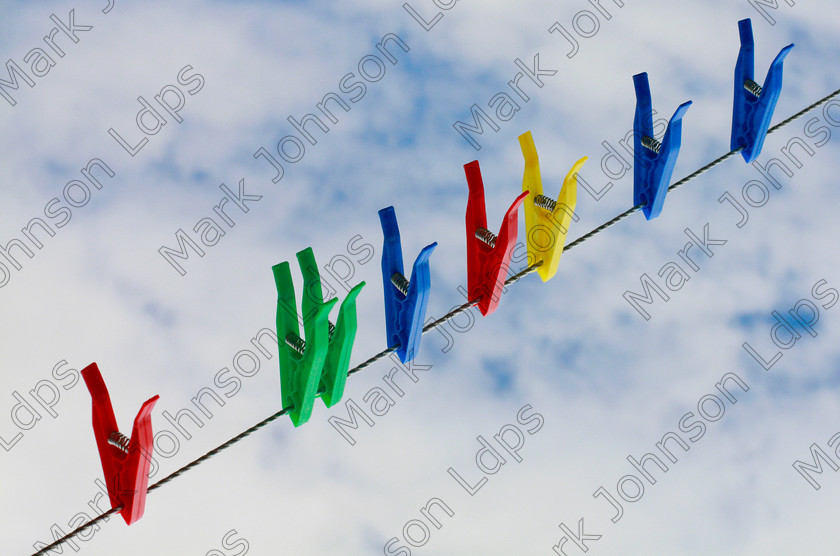MG 3568 
 These clothes pegs were caught walking accross our washing line when they thought no one was watching! 
 Keywords: Mark Johnson, clothes pegs, plastic, vibrant, red, blue, green, yellow, rgby, sky, cloud